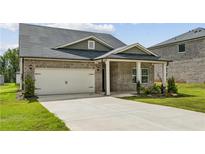 Brick house with a two-car garage and a covered porch at 7788 Richmond Trl, Fairburn, GA 30213