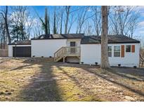Newly renovated home with white siding, dark brown accents, and a deck at 3251 Stoney Acres Nw Dr, Kennesaw, GA 30152