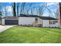 Charming ranch-style home with a well-maintained lawn and a detached garage at 3251 Stoney Acres Nw Dr, Kennesaw, GA 30152