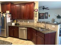 Spacious kitchen with dark wood cabinets, granite countertops, and stainless steel appliances at 709 Chapman St, Jonesboro, GA 30238