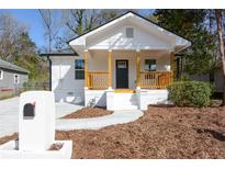Charming white house with a wooden porch and well-maintained landscaping at 849 Wood Nw St, Atlanta, GA 30318