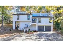 Stunning two-story home with gray and white exterior, attached garage, and landscaping at 2490 Woodfern Ct, Marietta, GA 30062