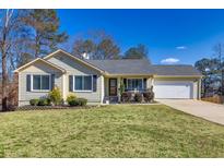 Ranch style home with landscaped lawn, attached garage, and neutral siding at 775 Holcombe Woods Ct, Auburn, GA 30011