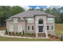 Brick two-story home with landscaped yard and large driveway at 3317 Steeple Chase Way, Conyers, GA 30094