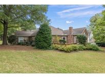 Brick ranch home with private backyard, green lawn, and mature trees at 1920 Kolb Farm Sw Cir, Marietta, GA 30008