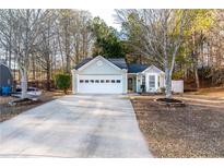 Charming light green house with a white garage door and landscaping at 2403 Barndale Dr, Lawrenceville, GA 30044