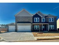 Two-story home with gray brick and a three-car garage at 138 Longhorn Way, Auburn, GA 30011