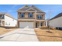Two-story brick home with a white garage door and landscaping at 6094 Whitetail Deer Run, Mableton, GA 30126