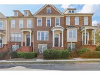 Three-story townhouses with brick and stone facade, landscaping, and staircases at 2367 Millhaven Se St # 15, Smyrna, GA 30080