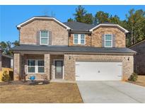 Two-story brick home with a large driveway and landscaped lawn at 7767 Richmond Trl, Fairburn, GA 30213