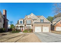 Two-story brick home with a three-car garage and manicured lawn at 552 Lawton Bridge Sw Rd, Smyrna, GA 30082