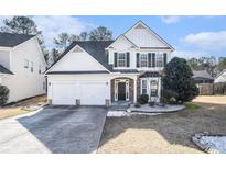 Two-story house with a two-car garage and landscaped lawn at 3055 Cooper Woods Ln, Loganville, GA 30052