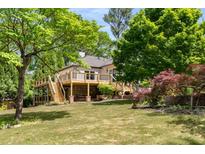 A backyard view of a home with a new deck overlooking a well-maintained lawn and mature trees, creating a peaceful outdoor space at 490 Rock Springs Ne Rd, Atlanta, GA 30324