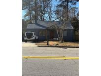 Cute bungalow with a gray exterior, nicely landscaped yard, and a driveway at 1876 Connally Dr, East Point, GA 30344