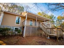 Tan house with stone accents, double garage, and wraparound deck at 255 Rocky Ridge Dr, Douglasville, GA 30134
