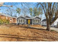 Charming gray house with yellow door, surrounded by trees and landscaping at 74 Austin Ne Ave, Marietta, GA 30060
