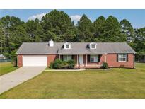 Brick ranch house with attached garage and spacious yard at 1308 Crumbley Rd, Mcdonough, GA 30252