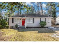 Charming brick ranch home with red door and landscaped lawn at 1903 Wildwood Dr, Decatur, GA 30032
