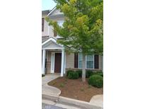 Tan two-story house with brown door, landscaping, and trees at 585 Mcwilliams Rd, Atlanta, GA 30315