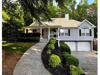 Charming home with a well-manicured front yard, two-car garage, and a welcoming front porch at 213 Moore Valley Way, Canton, GA 30115