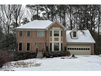 Two-story brick home with a snow covered front yard at 947 Pinbrook Dr, Lawrenceville, GA 30043