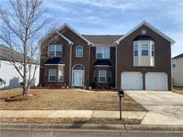 Brick two-story house with a two-car garage and landscaped yard at 1238 Polk Xing, Mcdonough, GA 30252
