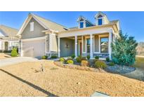 Charming home with a meticulously landscaped front yard and inviting covered porch with stately columns at 4941 Adler Ct, Hoschton, GA 30548