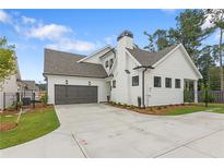 Stunning white farmhouse exterior with gray roof, two-car garage, and manicured lawn at 515 Pearl St, Cumming, GA 30040