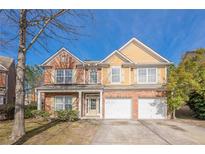 Charming two-story home featuring a brick and siding facade, attached two-car garage, and manicured landscaping at 1656 Hedington Ct, Lawrenceville, GA 30045