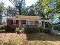 Brick ranch house with covered porch, driveway, and mature trees at 269 Florida Sw Ave, Atlanta, GA 30310