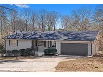 Newly renovated ranch home with gray garage door and landscaped yard at 2233 Troutdale Dr, Decatur, GA 30032