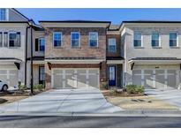 Brick front townhouse with two-car garage and landscaping at 3528 Myron Pl, Suwanee, GA 30024