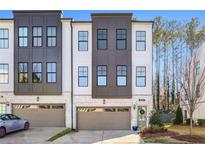 Modern three-story townhome with gray and white exterior, two-car garage, and landscaping at 6146 Eves Way, Norcross, GA 30071