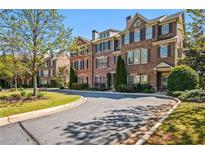 Charming brick townhomes with manicured lawns and mature trees lining the street at 570 Parkside Village Nw Way # 12, Marietta, GA 30060