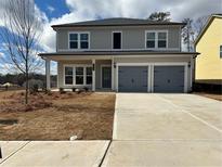 Two story home featuring a two car garage, covered porch and neatly landscaped yard at 2112 Boxwood Se Cir, Conyers, GA 30094