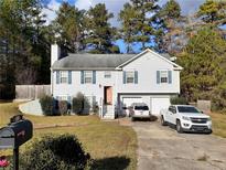 Two-story house with attached garage and driveway, nestled in a wooded area at 43 Lakemoore Ct, Douglasville, GA 30134
