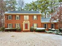 Brick house with a snow-covered lawn at 215 Heirloom Ct, Alpharetta, GA 30022