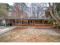 Charming brick home with a covered front porch and well-maintained landscaping at 4225 Parkridge Dr, Powder Springs, GA 30127