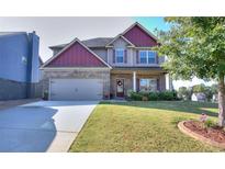 Two-story brick home with a large front yard and attached garage at 1058 Hartwell Rd, Locust Grove, GA 30248