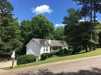 House exterior showcasing a white ranch home with landscaping and a driveway at 165 Lost Lake Trl, Villa Rica, GA 30180