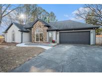 House exterior featuring stone accents and a two-car garage at 3529 Elinburg Ct, Buford, GA 30519