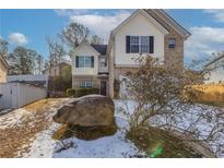 Two-story house with brick and siding exterior, large yard, and a stone in front at 3506 Creekview Dr, Union City, GA 30291