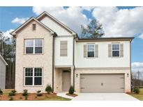 Charming two-story home with a brick and siding exterior, complemented by a well-manicured lawn and two-car garage at 7289 Eton Ln, Locust Grove, GA 30248
