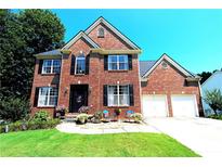 Brick two-story house with a two car garage and landscaping at 3854 Heritage Crest Pkwy, Buford, GA 30519