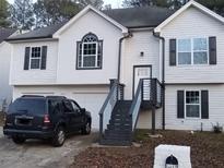 Two story house with gray accents and a modern staircase at 5619 Mayfair Crossing Dr, Lithonia, GA 30038