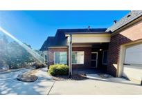 Lovely brick home with a covered outdoor seating area and a well-maintained landscape under a clear blue sky at 4140 Lanier Ridge Walk # 104, Cumming, GA 30041