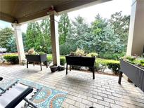 Covered patio has pavers, container plants, and furniture at 4140 Lanier Ridge Walk # 104, Cumming, GA 30041