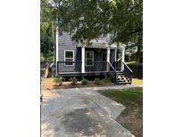 Two-story gray house with a front porch, steps, and driveway at 935 Pelham Nw St, Atlanta, GA 30318