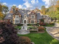Stone chateau-style home with manicured landscaping and circular driveway at 3685 Paces Ferry Nw Rd, Atlanta, GA 30327