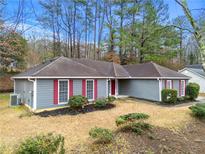 Charming single-story home featuring a well-maintained front yard with mature trees and a gray exterior at 2065 Arbor Forest Sw Dr, Marietta, GA 30064
